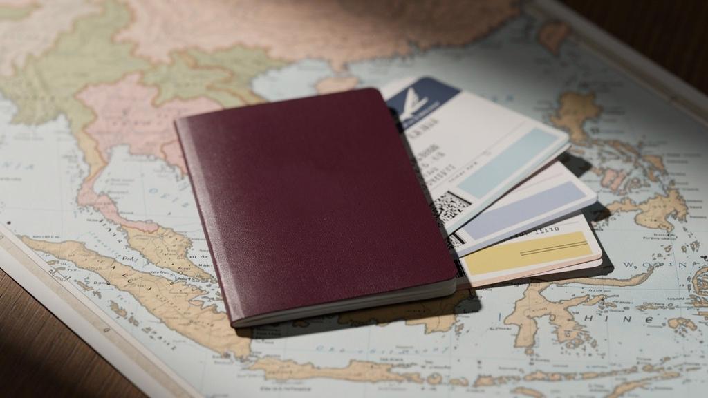 Passeport français et billets d'avion posés sur une carte de l'Asie du Sud-Est